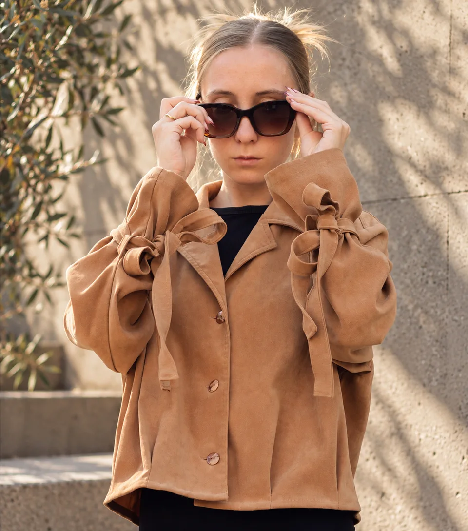 Dejvice 10 – close-up of bow ties on both sleeves of the brown blazer