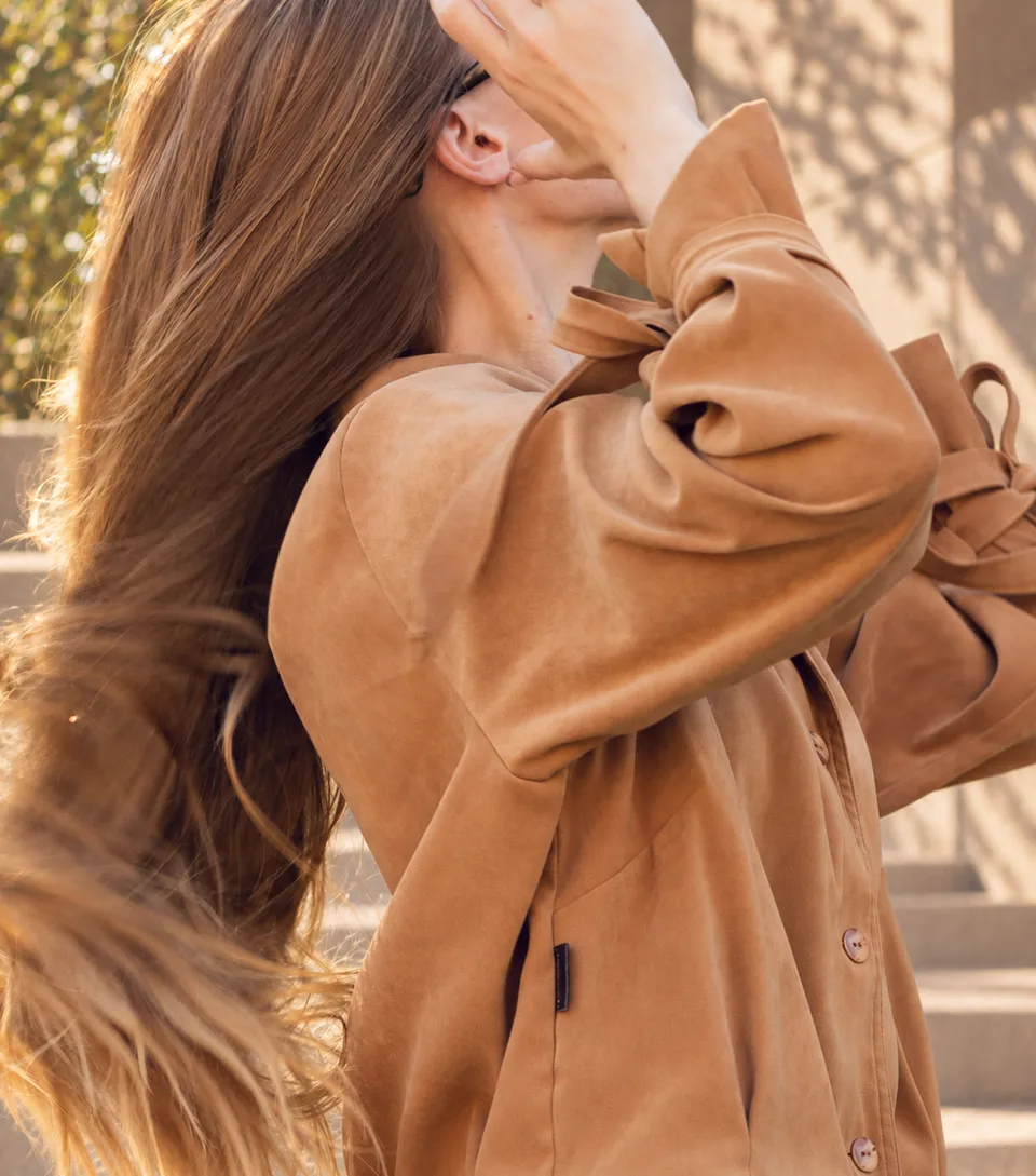Dejvice 10 – detail of a caramel-brown blazer with a bow on the sleeve