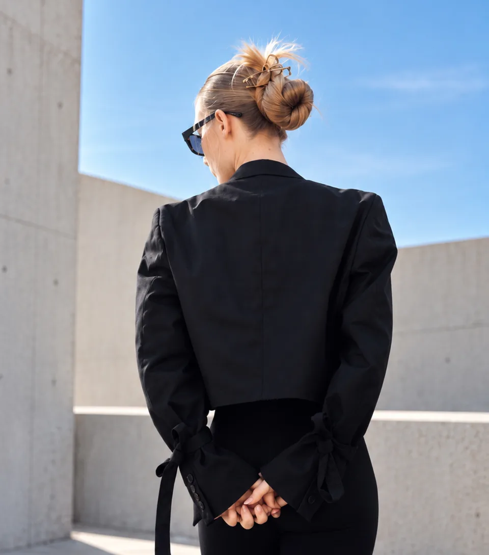 Back view of Dejvice 11 cropped black blazer with sleeve bows